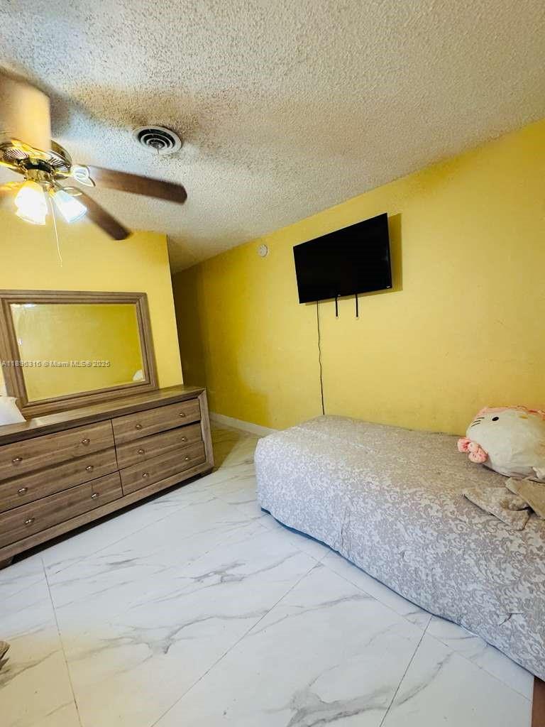 3405 Northwest 82nd Avenue Coral Springs, FL 33065 - Photo 13 of 26 a bedroom with a bed and a painting on the wall