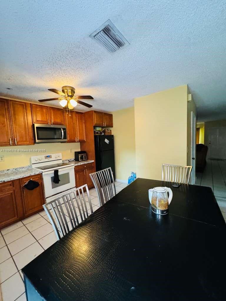 3405 Northwest 82nd Avenue Coral Springs, FL 33065 - Photo 23 of 26 a kitchen with granite countertop a stove and cabinets