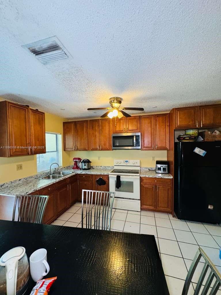 3405 Northwest 82nd Avenue Coral Springs, FL 33065 - Photo 25 of 26 a kitchen with stainless steel appliances granite countertop a stove a sink and a refrigerator