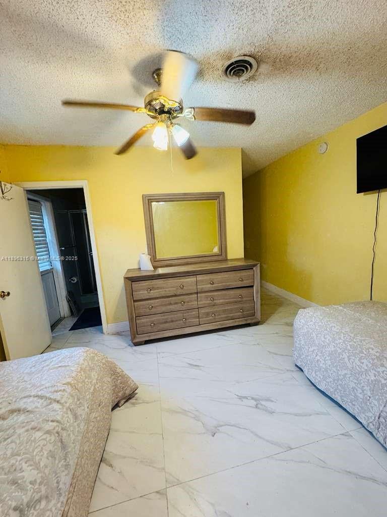 3405 Northwest 82nd Avenue Coral Springs, FL 33065 - Photo 9 of 26 a spacious bedroom with a bed and a ceiling fan