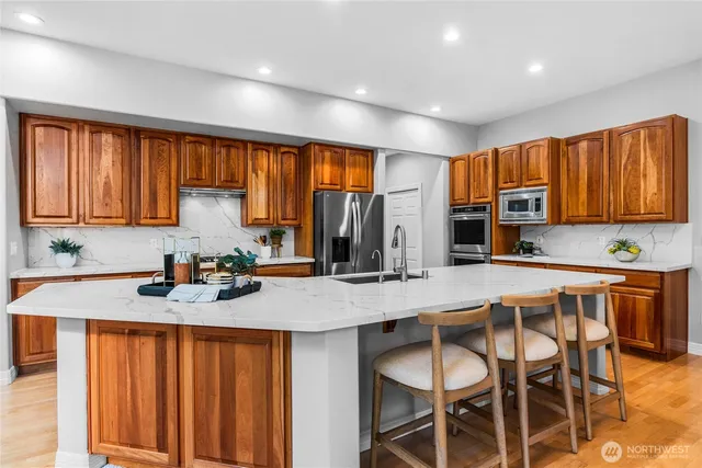 a kitchen with stainless steel appliances granite countertop wooden cabinets a stove top oven a sink and dishwasher