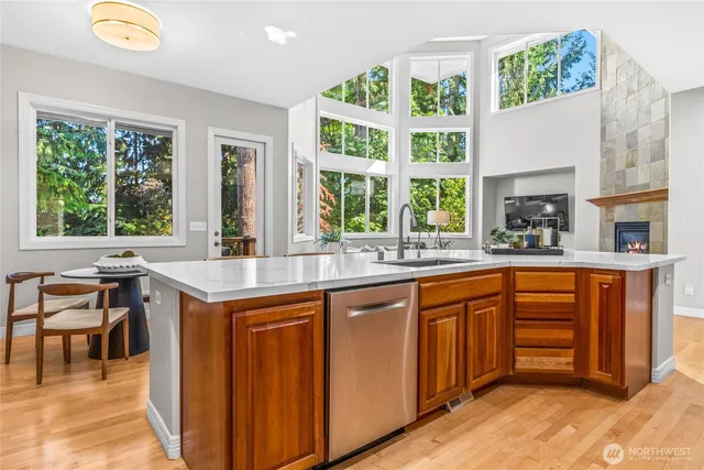 a kitchen with stainless steel appliances granite countertop wooden cabinets a sink and a large window