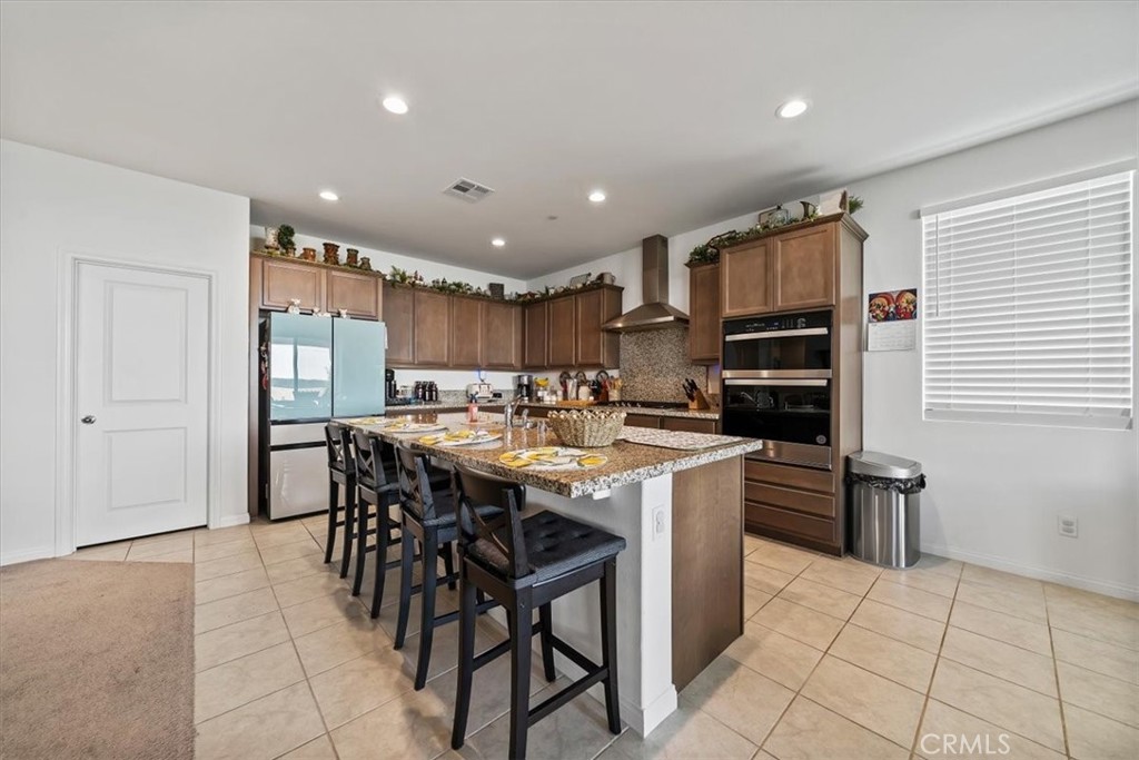 12766 Blush Court Riverside, CA 92503 - Photo 13 of 55 a kitchen with stainless steel appliances kitchen island granite countertop a sink and cabinets