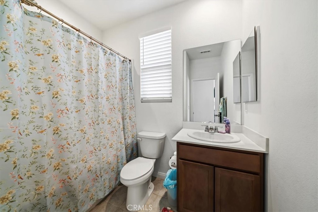 12766 Blush Court Riverside, CA 92503 - Photo 24 of 55 a bathroom with a toilet a sink a mirror and a shower