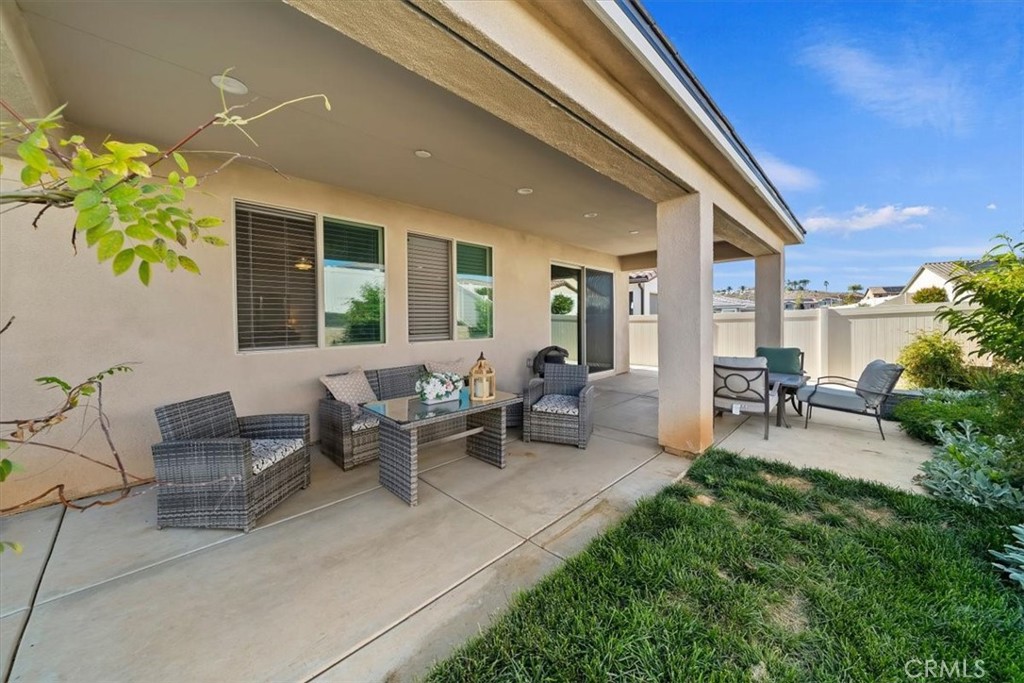 12766 Blush Court Riverside, CA 92503 - Photo 46 of 55 a view of a patio with table and chairs potted plants and floor to ceiling window