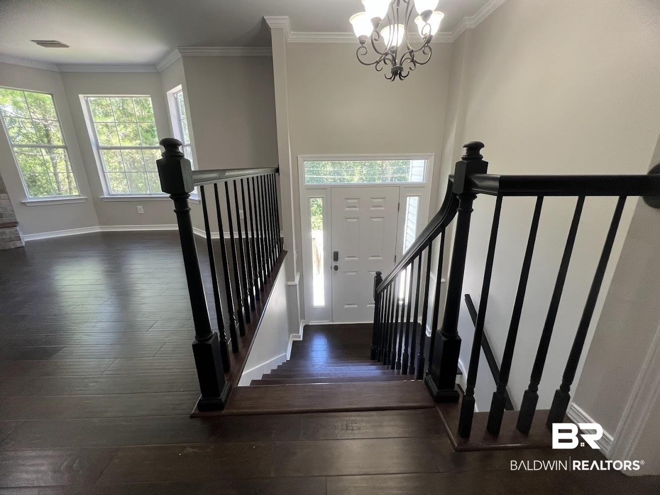 266 Ridgewood Drive Daphne, AL 36526 - Photo 4 of 34 Entryway staircase featuring dark wood-finish treads and risers with black balusters and handrails