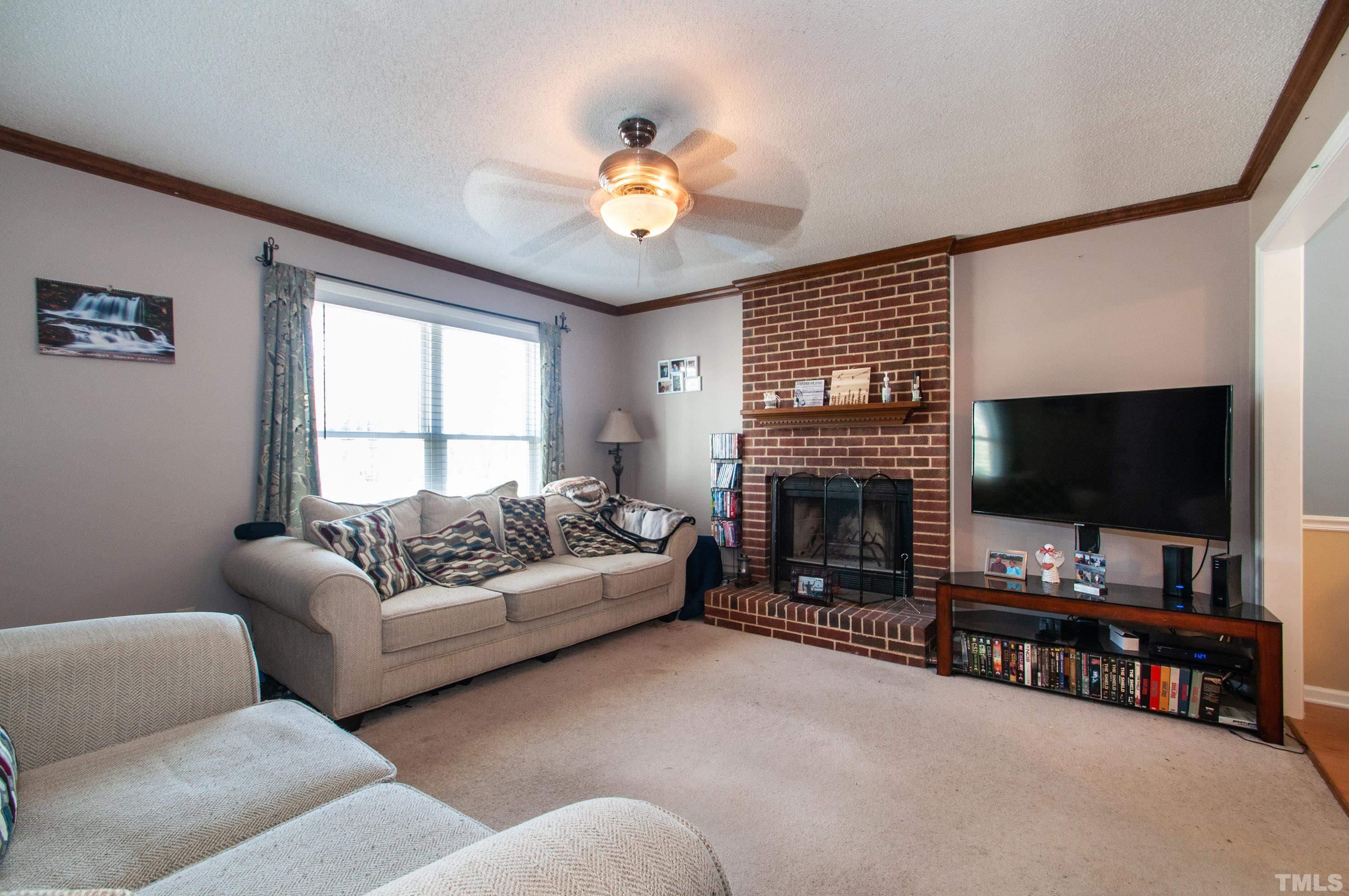 3605 Castlegate Drive Raleigh, NC 27616 - Photo 4 of 18 a living room with fireplace furniture and a flat screen tv
