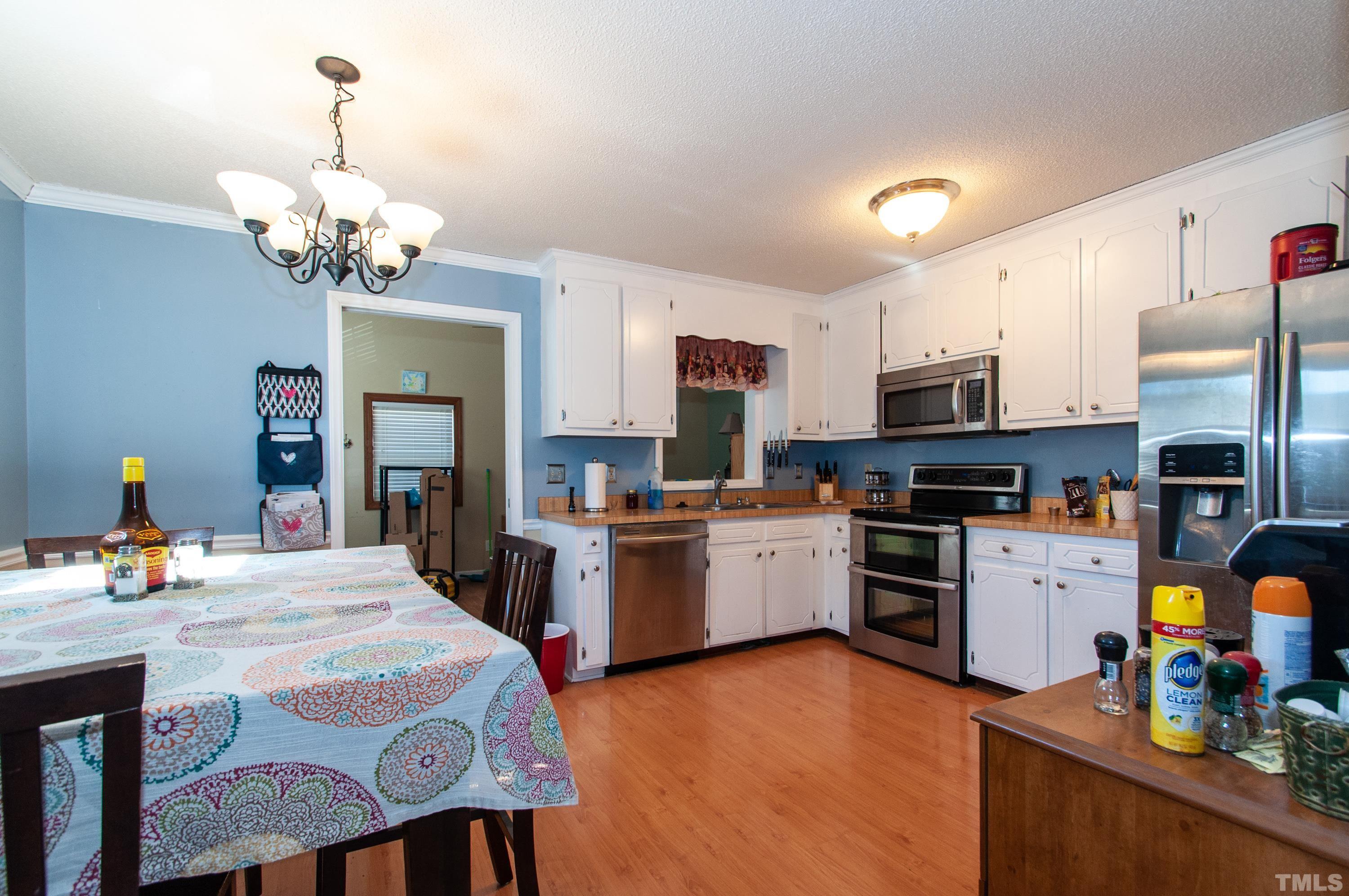 3605 Castlegate Drive Raleigh, NC 27616 - Photo 6 of 18 a kitchen with stainless steel appliances granite countertop a stove refrigerator and a dining table with wooden floor
