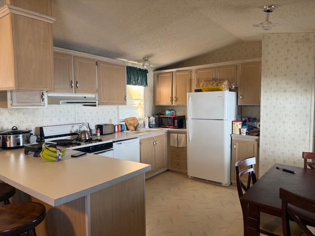 2500 Highway 59, Unit 270 Merced, CA 95348 - Photo 3 of 14 a kitchen with a refrigerator a stove a sink dishwasher a stove and white countertops with wooden floor