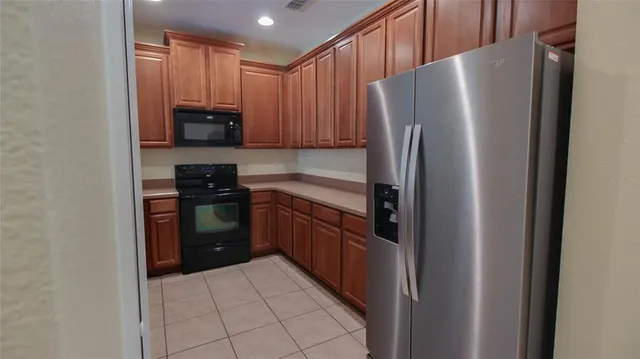 a kitchen with stainless steel appliances granite countertop a refrigerator and a stove top oven