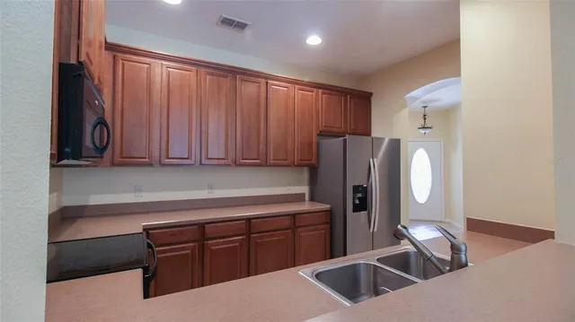 a kitchen with stainless steel appliances granite countertop a refrigerator and a sink