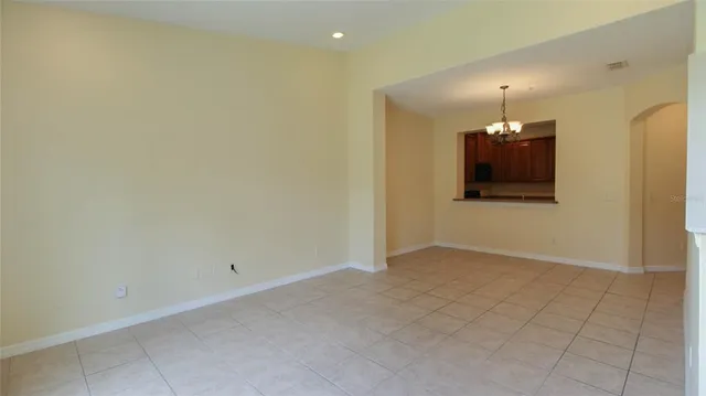an empty room with wooden floor and chandelier fan
