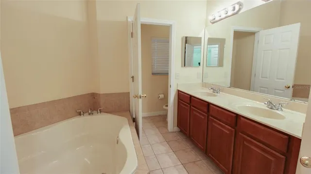 a spacious bathroom with a tub sink and mirror
