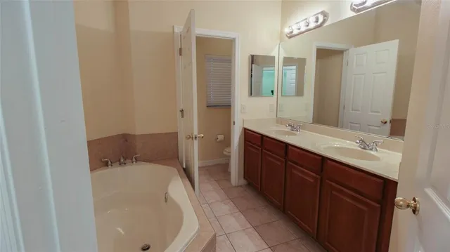 a en suite bathroom with a double vanity sink and mirror