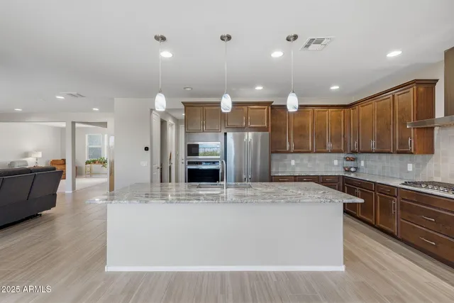 a kitchen with stainless steel appliances granite countertop a sink stove and refrigerator