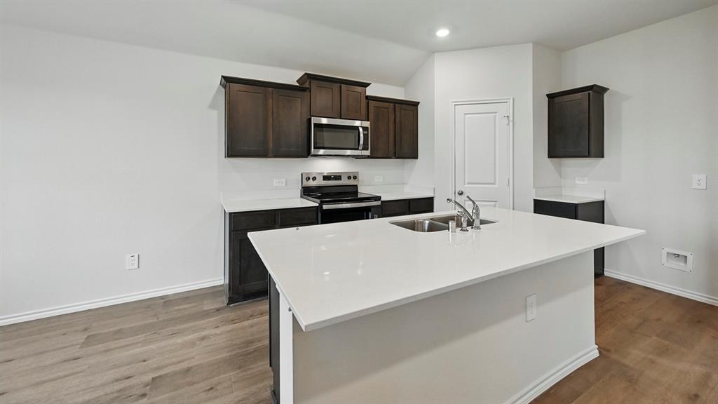 3925 Oakcrest Lane Princeton, TX 75407 - Photo 20 of 35 a white kitchen with a sink a microwave and wooden cabinets