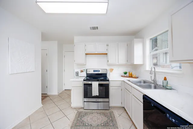 a kitchen with a stove top oven sink and cabinets