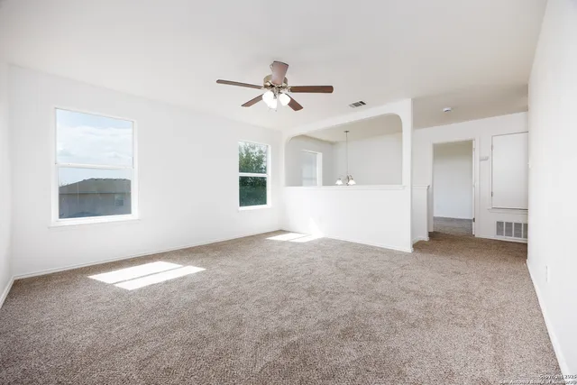 an empty room with a bathroom and a window