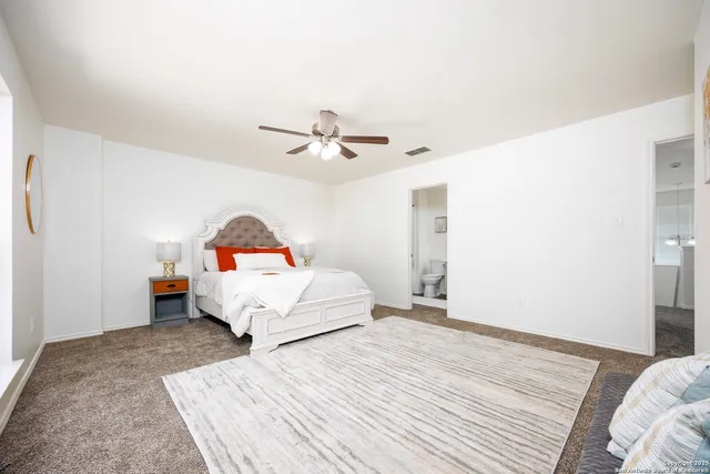 a bedroom with a bed and a ceiling fan