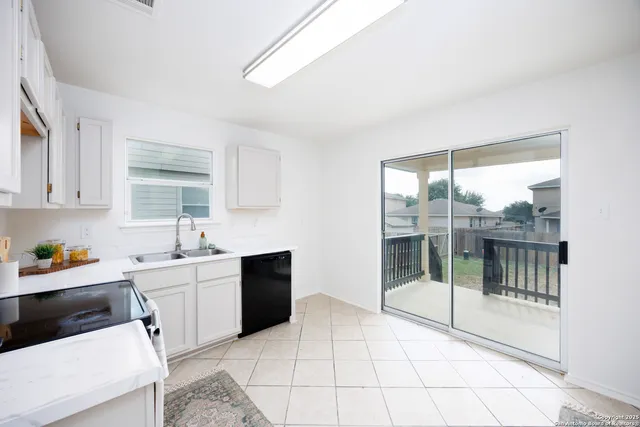 a kitchen with a sink and white cabinets