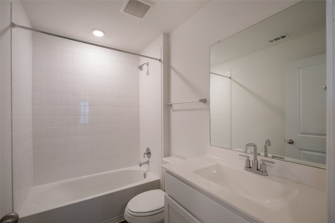 15009 Welsh Cob St Manor, Unit A Manor, TX 78653 - Photo 21 of 24 a bathroom with a granite countertop sink a toilet and shower