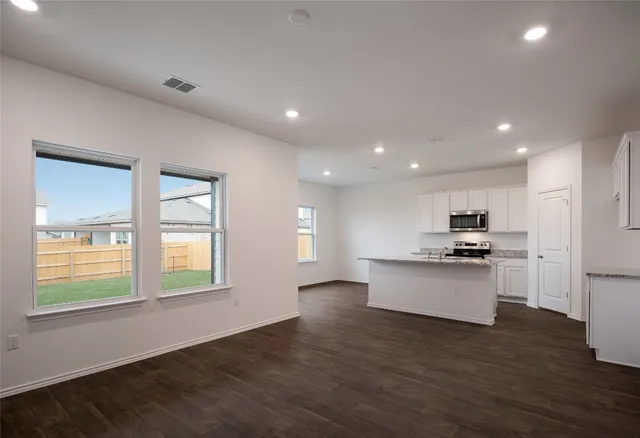 a view of a kitchen with wooden floor and electronic appliances