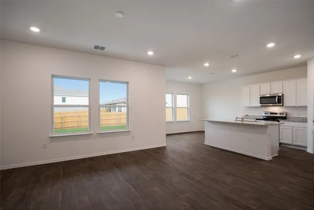 a kitchen with stainless steel appliances granite countertop a stove a sink and a microwave