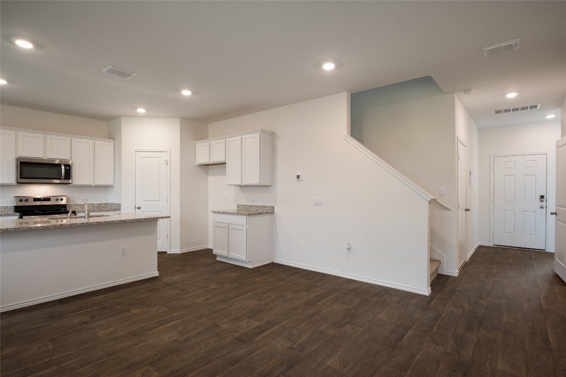 15009 Welsh Cob St Manor, Unit A Manor, TX 78653 - Photo 9 of 24 a view of a kitchen with wooden floor and electronic appliances