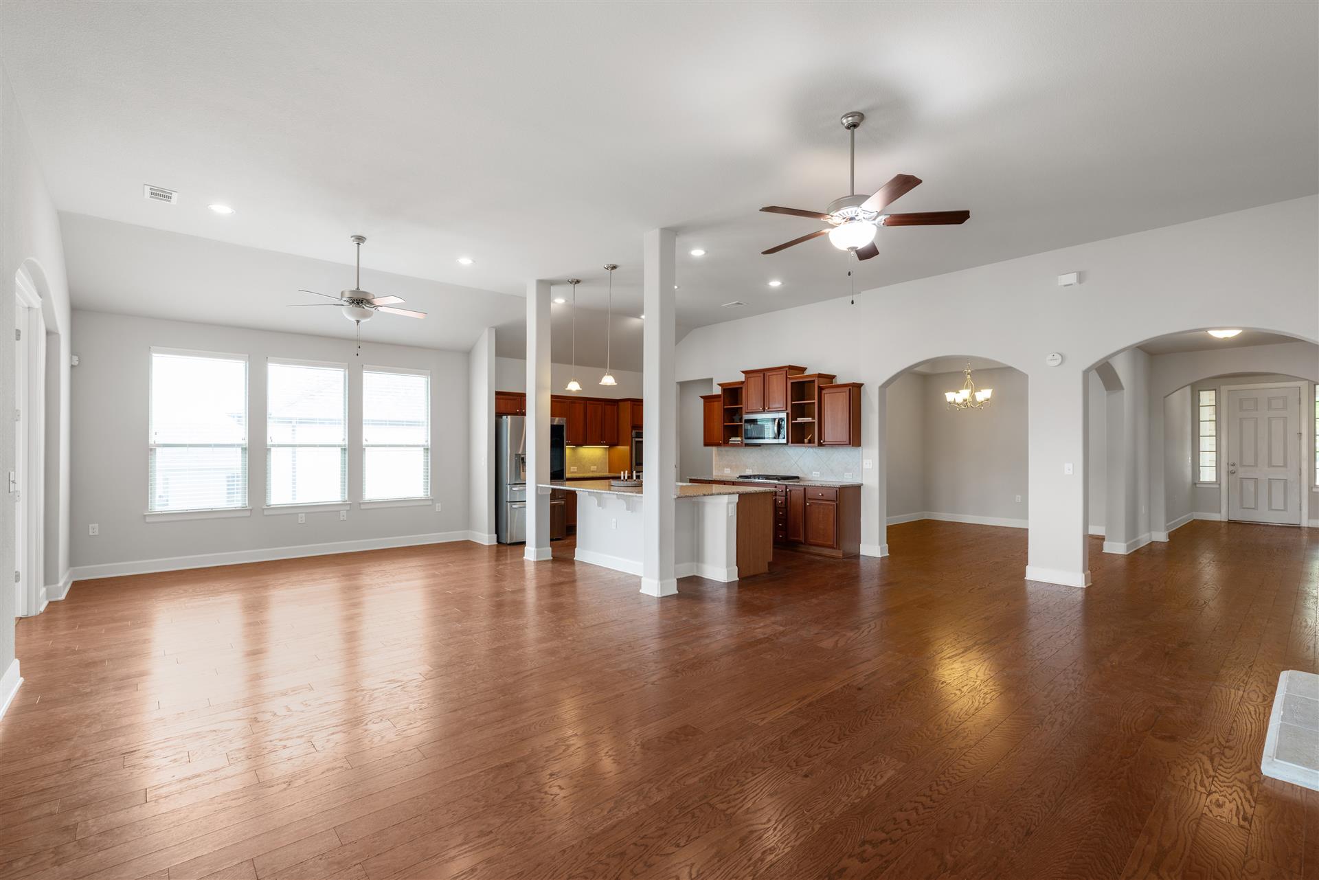 3516 Venezia View Leander, TX 78641 - Photo 4 of 40 Living room with a ceiling fan, dark wood finished floors, arched walkways, and recessed lighting