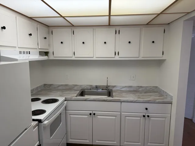 a kitchen with white cabinets and white appliances