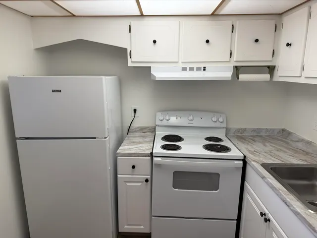 a white refrigerator freezer sitting inside of a kitchen