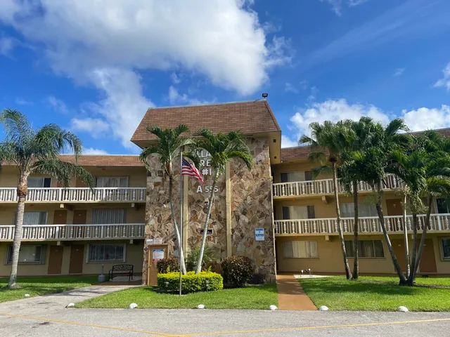 a front view of a building with a garden and plants