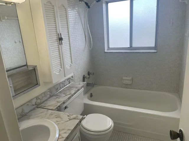 a white bath tub sitting next to a toilet