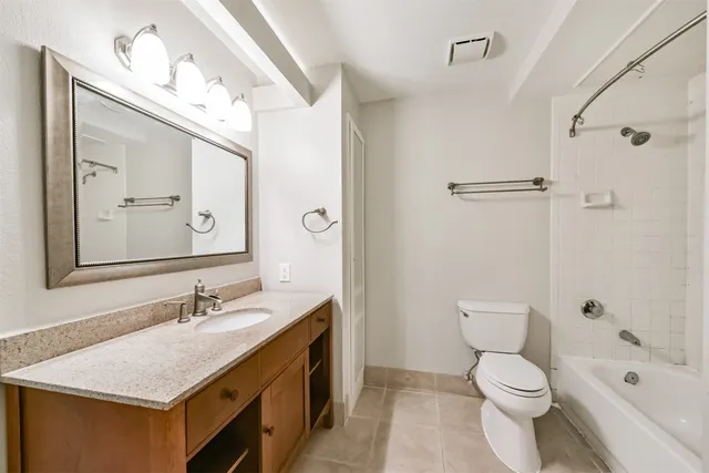 a bathroom with a granite countertop sink toilet and shower