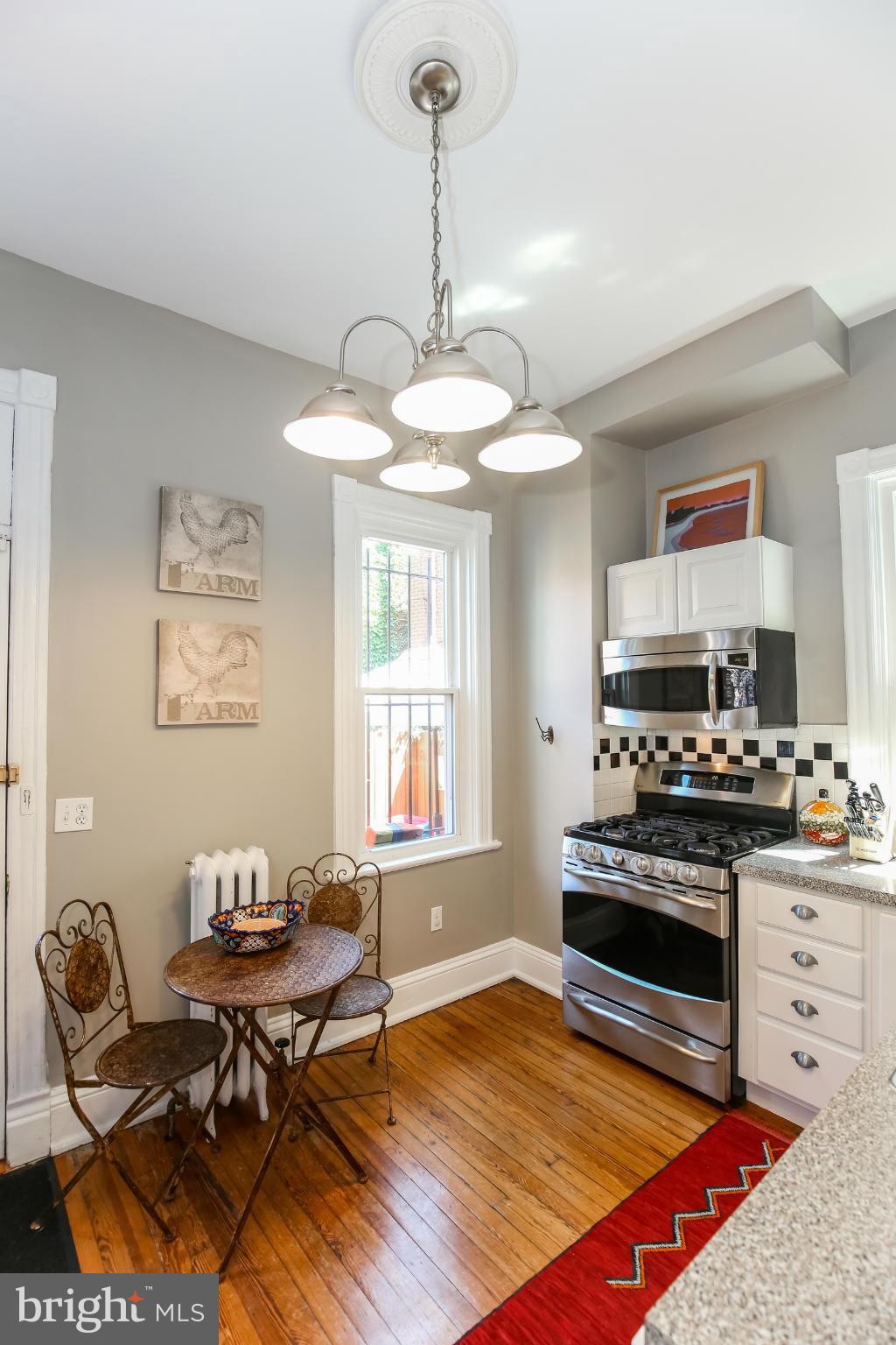 252 8th Street Southeast Washington, DC 20003 - Photo 11 of 29 a living room with dining area furniture a chandelier and a window