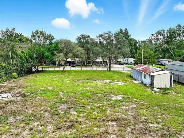 a view of a house with a big yard and sitting area