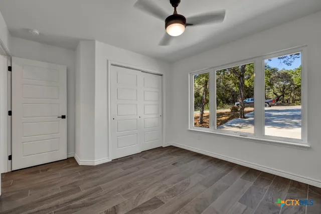an empty room with wooden floor and windows