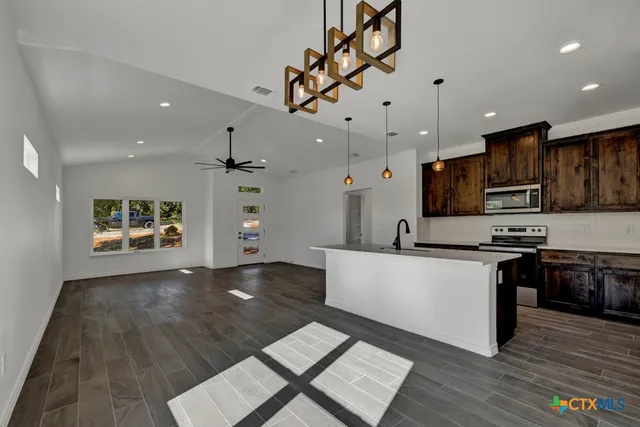 a large kitchen with cabinets wooden floor and stainless steel appliances