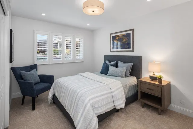 a bedroom with bed and a large window