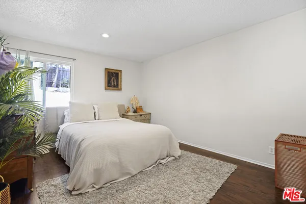a bedroom with a bed and a potted plant
