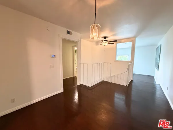 a view of a room with wooden floor staircase and a kitchen