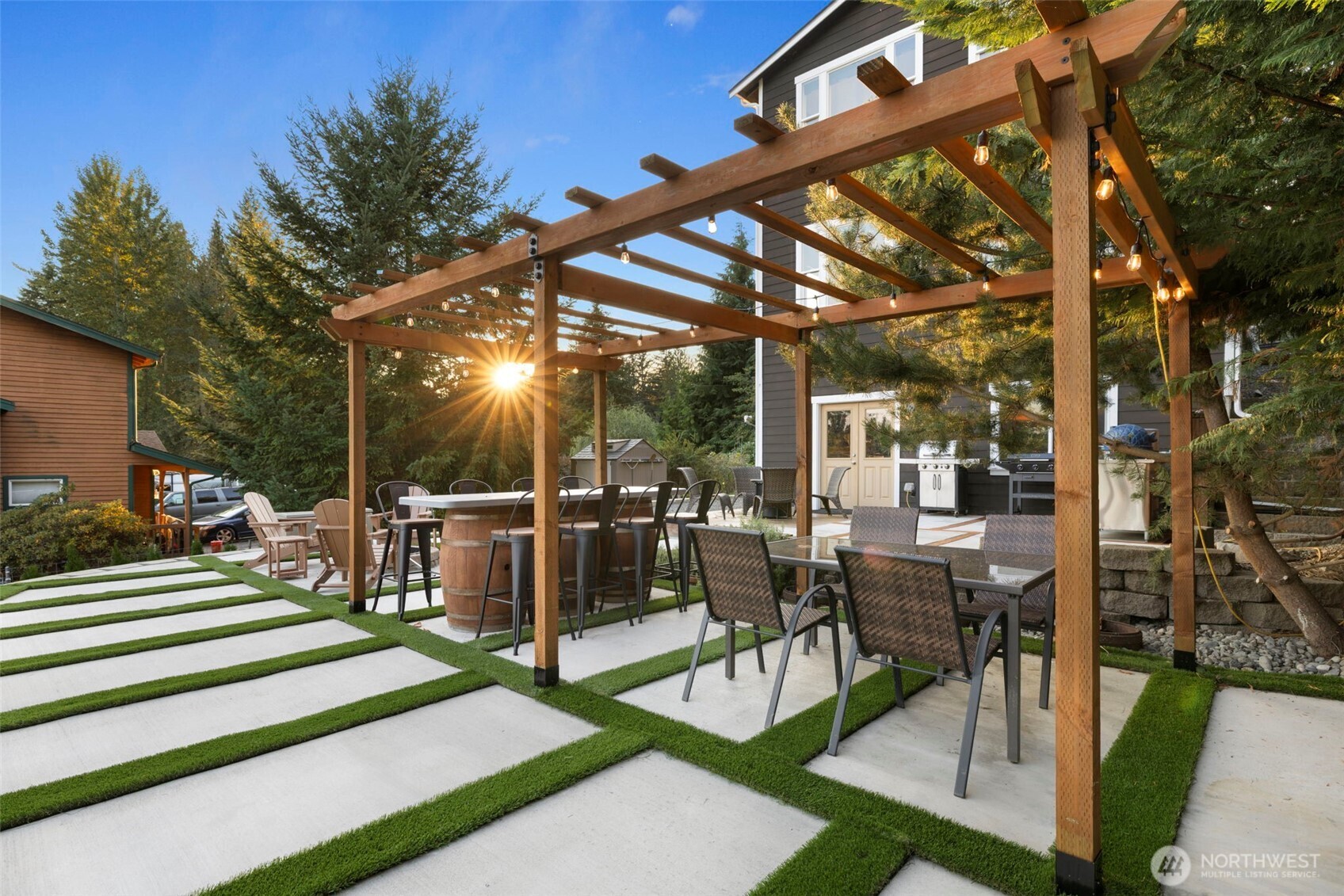 12203 Rainbow Road Arlington, WA 98223 - Photo 31 of 40 a view of a patio with table and chairs potted plants and large tree