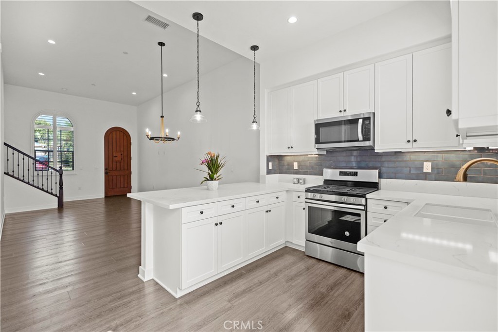 1672 3rd Street Duarte, CA 91010 - Photo 7 of 30 a kitchen with stainless steel appliances kitchen island granite countertop a stove a sink and a refrigerator