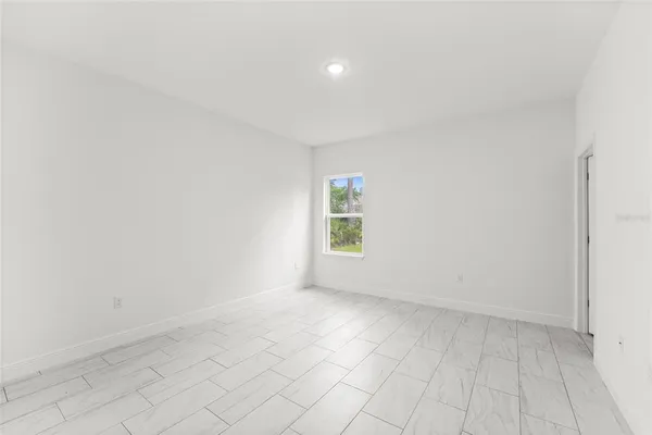 a backyard of a house with plants and large tree