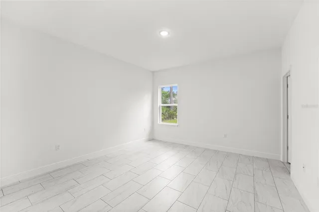 a backyard of a house with plants and large tree