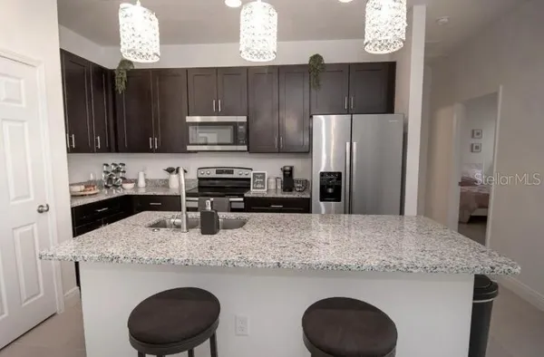 a kitchen with stainless steel appliances granite countertop a sink stove and cabinets