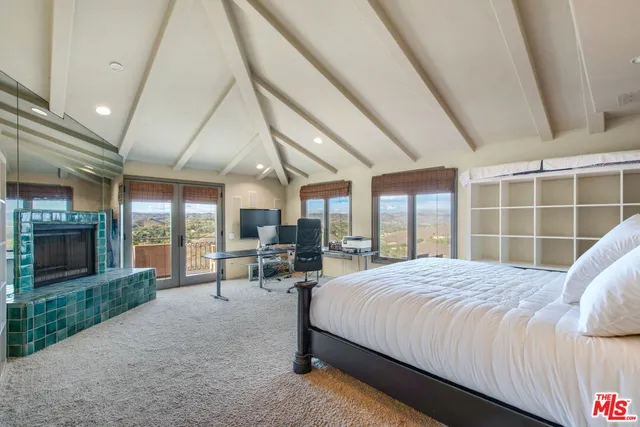 a large bedroom with a bed and large windows