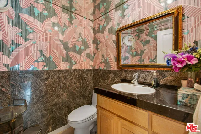 a bathroom with a granite countertop sink and a mirror