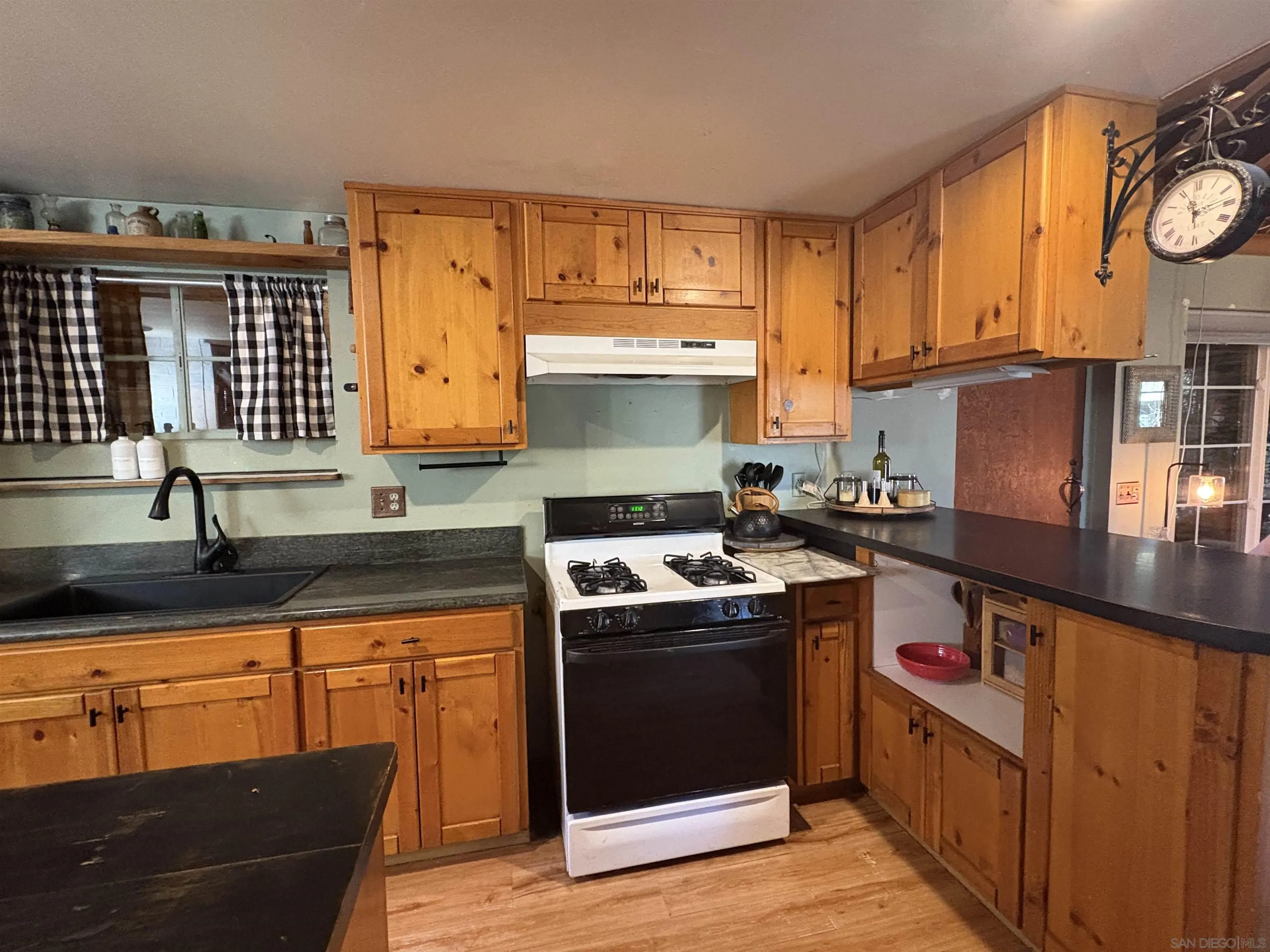 22188 Crestline Road Palomar Mountain, CA 92060 - Photo 26 of 69 a kitchen with kitchen island granite countertop a sink cabinets and stainless steel appliances