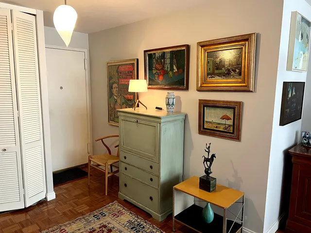 a view of a workspace with furniture and paintings on the wall